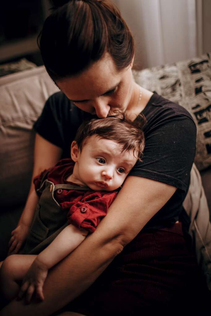 A mother holding her baby after winning a child custody case in Chico, CA
