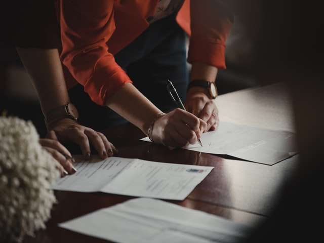 An individual signing paperwork drafted by a divorce lawyer
