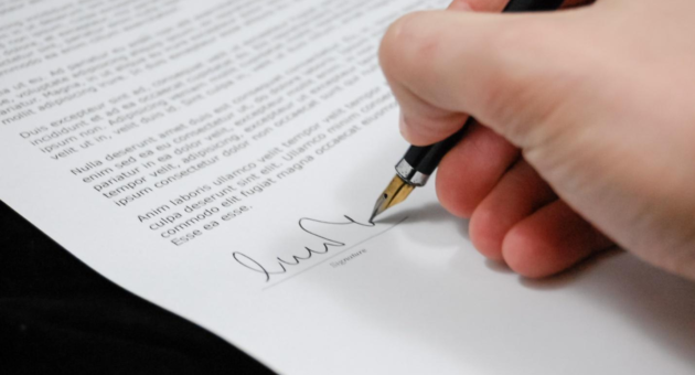 person signing a paper