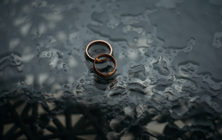 Two wedding rings on a watery surface
