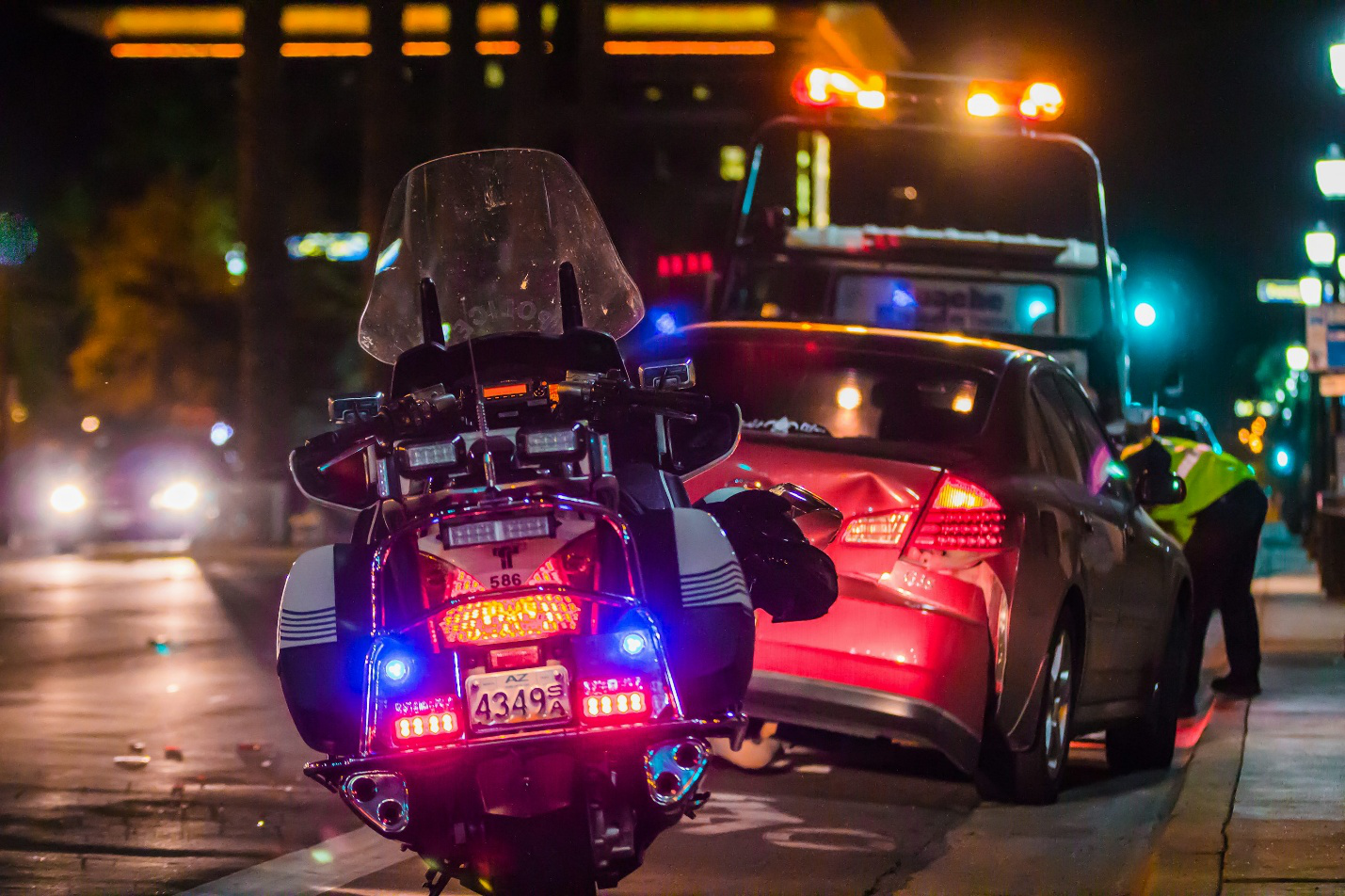 A police officer standing next to a red car before getting a bilingual criminal defense attorney in Tijuana, Mexico