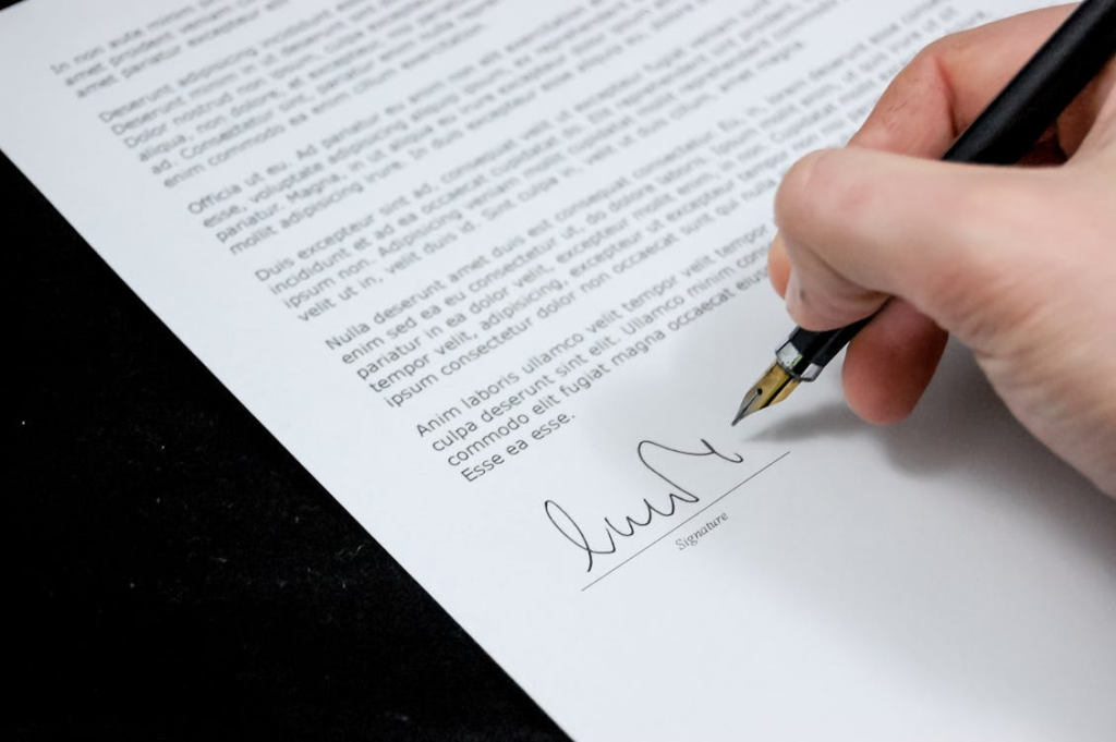 close-up of a person holding an ink pen, signing signing
