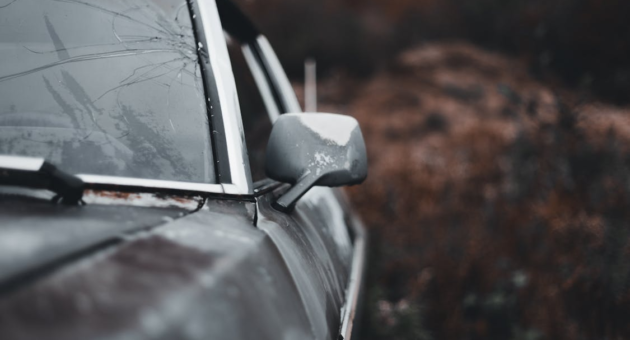 a car with a broken windshield and a weathered look