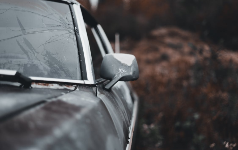 a car with a broken windshield and a weathered look