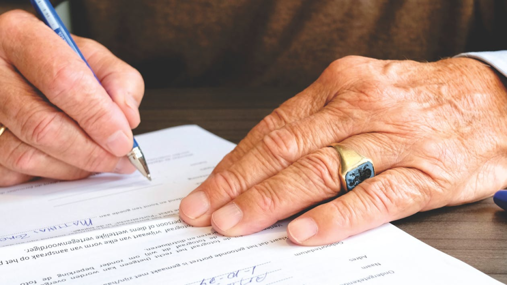 close-up of a person signing a document close-up of a person signing a document