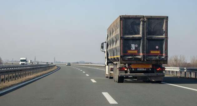 rear end of a truck on an empty expressway against the sky