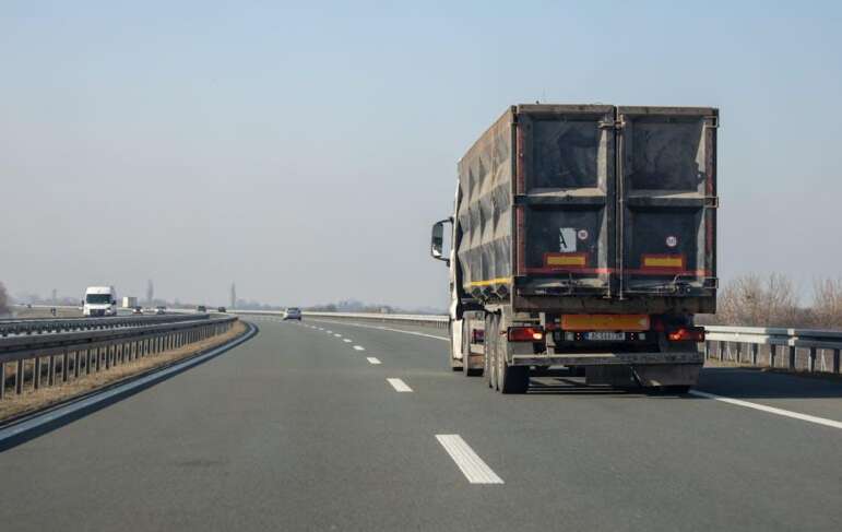 rear end of a truck on an empty expressway against the sky