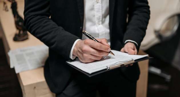 An image of a person signing some papers