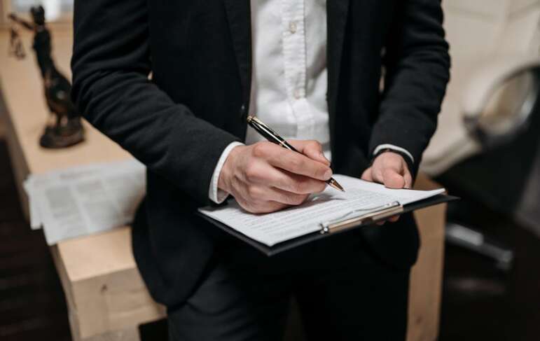 An image of a person signing some papers