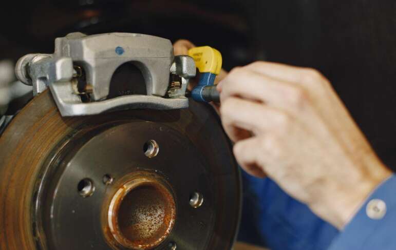 Brake system complaints deserve prompt attention and accurate service records. Image search: mechanic examining car brake disc
